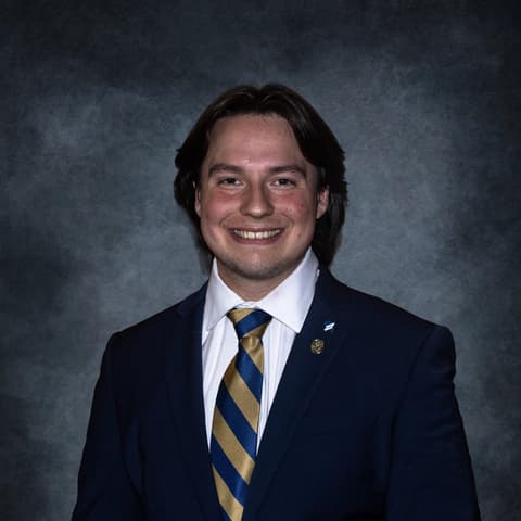 Portrait of Elijah Diaz in a suit and tie